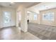 Inviting entryway featuring tile flooring and a decorative glass front door leading to a spacious, carpeted living area at 5260 Acqua Ln, Pahrump, NV 89061