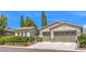 Beautifully maintained home featuring a three-car garage, lush landscaping, and a welcoming entrance at 5260 Acqua Ln, Pahrump, NV 89061