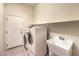 Well-equipped laundry room including washer, dryer, utility sink, and shelving at 5260 Acqua Ln, Pahrump, NV 89061