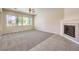 Bright living area featuring a fireplace, ceiling fan, large windows, and neutral carpet and tile flooring at 5260 Acqua Ln, Pahrump, NV 89061