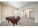 Elegant living room with a grand piano, chandelier, and large windows offering natural light at 5260 Acqua Ln, Pahrump, NV 89061
