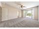 Expansive main bedroom with carpet, neutral walls, ceiling fan, and access to the backyard through sliding glass doors at 5260 Acqua Ln, Pahrump, NV 89061