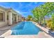 Beautiful backyard pool with a covered patio and steps, surrounded by lush landscaping at 5260 Acqua Ln, Pahrump, NV 89061