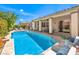 A beautiful backyard featuring a pristine pool, lounge chairs, and covered patio at 5260 Acqua Ln, Pahrump, NV 89061