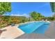Sparkling pool with well-maintained landscaping, surrounded by lush greenery and a bright blue sky at 5260 Acqua Ln, Pahrump, NV 89061
