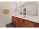 Bathroom with double sinks, wood vanity and large mirror at 5310 Eel River Ct, North Las Vegas, NV 89031