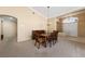 Elegant dining area with a wood table and chairs, bright chandelier, and carpet flooring at 5310 Eel River Ct, North Las Vegas, NV 89031