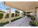 Relaxing covered patio with a manicured lawn, stone pavers, and a lush green space for outdoor enjoyment at 5310 Eel River Ct, North Las Vegas, NV 89031