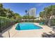 Community pool surrounded by a secure fence, offering a refreshing recreational space with lounge chairs at 590 Tam O Shanter, Las Vegas, NV 89109