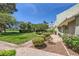 Landscaped community yard with a brick-paved walkway that is lined with lush greenery and flowering bushes at 590 Tam O Shanter, Las Vegas, NV 89109