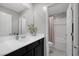 Bathroom features a dark vanity cabinet with white countertop, large mirror, decorative greenery, and shower/tub combo at 6247 Milford Sound St, Las Vegas, NV 89148