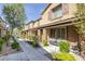 Inviting two-story townhomes feature walkways, desert landscaping, and a cozy bench near the entryway at 6247 Milford Sound St, Las Vegas, NV 89148