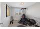 Brightly lit home gym featuring carpeted floor, window, exercise equipment and a framed sports jersey on the wall at 6247 Milford Sound St, Las Vegas, NV 89148