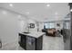 Kitchen island flows into a living room area, stainless appliances and gray tile floor at 6247 Milford Sound St, Las Vegas, NV 89148