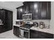 Close-up of the kitchen with stainless steel appliances and dark wood cabinets at 6247 Milford Sound St, Las Vegas, NV 89148