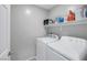 Brightly lit laundry room featuring a stacked washer and dryer and a shelf for storage at 6247 Milford Sound St, Las Vegas, NV 89148