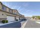 Long shot of street lined with townhomes, each featuring a two-car garage at 6247 Milford Sound St, Las Vegas, NV 89148
