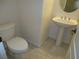 Standard half-bathroom featuring a toilet and a pedestal sink with a round mirror at 7649 Slide Rock Ave, Las Vegas, NV 89113