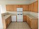 Galley kitchen showcasing wood cabinets, laminate countertops, and white appliances at 7971 Duneville St, Las Vegas, NV 89139
