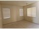 Vacant living room featuring tile flooring, neutral paint, and two large windows at 7971 Duneville St, Las Vegas, NV 89139