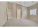Bedroom with carpet, high ceilings, ceiling fan, and doorways to the bathroom and closet at 8125 Turbys Treehouse Pl, Las Vegas, NV 89131