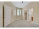 Bedroom with neutral carpet, multiple doors, and plantation shutters on windows at 8125 Turbys Treehouse Pl, Las Vegas, NV 89131