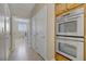Hallway with double ovens and view of the laundry room with washer and dryer at 8125 Turbys Treehouse Pl, Las Vegas, NV 89131