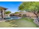 This backyard features a luxurious pool, turf, patio, and lush landscaping, perfect for outdoor living at 8125 Turbys Treehouse Pl, Las Vegas, NV 89131