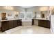 Spacious bathroom showcasing dual vanities, a soaking tub, and tile flooring with neutral walls at 8137 Crushed Velvet Pl, Las Vegas, NV 89166