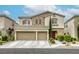 Charming two-story home featuring a stone facade, three-car garage, and well-manicured landscaping at 8137 Crushed Velvet Pl, Las Vegas, NV 89166