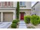 Inviting front entrance with stone accents, a red front door, and manicured landscaping at 8137 Crushed Velvet Pl, Las Vegas, NV 89166