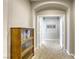 Hallway with carpet and neutral walls leading to an arched doorway with glass shelves at 8137 Crushed Velvet Pl, Las Vegas, NV 89166