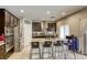 Modern kitchen featuring dark wood cabinets, stainless steel appliances, and a breakfast bar at 8137 Crushed Velvet Pl, Las Vegas, NV 89166
