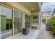 Covered patio area with seating and sliding glass doors leading to the house and yard at 8137 Crushed Velvet Pl, Las Vegas, NV 89166