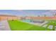 Expansive backyard featuring a modern pool, spa, waterfall features, and pristine artificial turf at 8310 W Camero Ave, Las Vegas, NV 89113
