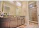 Well-lit bathroom with dual sinks, modern fixtures, and a walk-in shower with decorative tile at 8310 W Camero Ave, Las Vegas, NV 89113