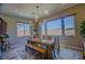 Airy dining room featuring a modern light fixture, picture windows, and comfortable seating at 8310 W Camero Ave, Las Vegas, NV 89113