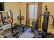 Home gym featuring weightlifting equipment, weight machine, mirror, rubber flooring, and a neutral color palette at 8310 W Camero Ave, Las Vegas, NV 89113