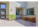 Relaxing outdoor patio area featuring brick pavers, a wooden dining table, and desert plants at 8310 W Camero Ave, Las Vegas, NV 89113