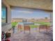 Covered patio with outdoor seating overlooking a modern pool, manicured lawn, and private backyard at 8310 W Camero Ave, Las Vegas, NV 89113