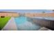 Backyard swimming pool showcasing modern waterfalls, an in-ground spa, and a lush green lawn at 8310 W Camero Ave, Las Vegas, NV 89113