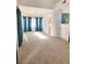 Bright living room features neutral carpet, lots of natural light and turquoise curtains at 8788 Elise Ct, Henderson, NV 89074