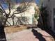 View of a backyard with a concrete block privacy wall, trees, and patio at 8829 Cornwall Glen Ave, Las Vegas, NV 89129