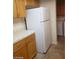 The kitchen features wooden cabinets, tiled countertops, and white appliances at 8829 Cornwall Glen Ave, Las Vegas, NV 89129