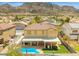 Aerial view of a home with a red tiled roof, a covered patio, backyard pool and mountain views at 885 Violet Hill St, Las Vegas, NV 89110