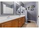 A full bathroom has dual sinks, wood cabinets, and decorative wall decor at 885 Violet Hill St, Las Vegas, NV 89110