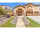 Charming two-story house with a three-car garage, manicured lawn, and inviting entryway at 885 Violet Hill St, Las Vegas, NV 89110