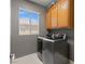 This laundry room has a front-load washer and dryer with storage cabinets at 885 Violet Hill St, Las Vegas, NV 89110