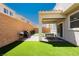Charming backyard space with artificial turf, patio area, and barbecue grill, ideal for relaxing and outdoor dining at 8929 Sleepy Panda Ave, Las Vegas, NV 89148