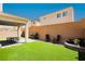 Low maintenance backyard with synthetic grass, covered patio, and brick perimeter wall at 8929 Sleepy Panda Ave, Las Vegas, NV 89148